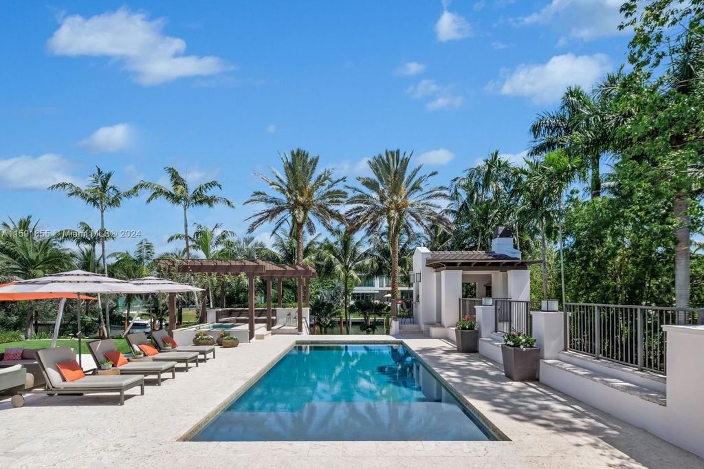 Designed by Christina Leon, this 13,147 square feet estate in Gables Estates offers unparalleled luxury. 4 beds and staff quarters, theater, gym, sauna, wine cellar, and expansive outdoor living with pool, jacuzzi, and private dock. Your waterfront paradise awaits!