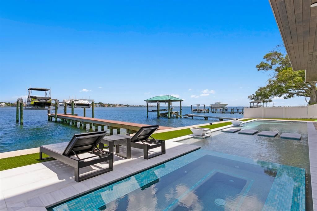 Rarely available NEW CONSTRUCTION! Live the dream in this 6-bedroom, 5.5-bath bayfront masterpiece. Sweeping water views, infinity pool, custom finishes, movie theater, wine cellar, and more in a sought-after school district. Available furnished.