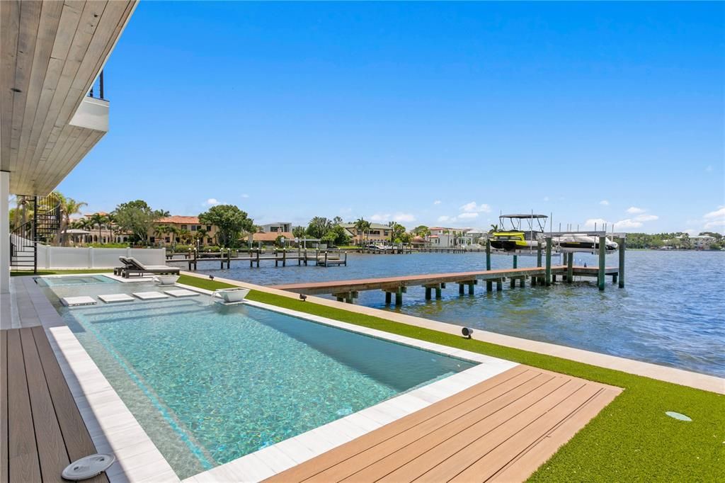 Rarely available NEW CONSTRUCTION! Live the dream in this 6-bedroom, 5.5-bath bayfront masterpiece. Sweeping water views, infinity pool, custom finishes, movie theater, wine cellar, and more in a sought-after school district. Available furnished.